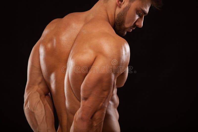 Sterke Atletische Mens - Geschiktheidsmodel die zijn perfecte die rug tonen op zwarte achtergrond met copyspace wordt geïsoleerd royalty-vrije stock foto Sterke Atletische Mens - Geschiktheidsmodel die zijn perfecte die rug tonen op zwarte achtergrond met copyspace wordt geïsoleerd royalty-vrije stock foto