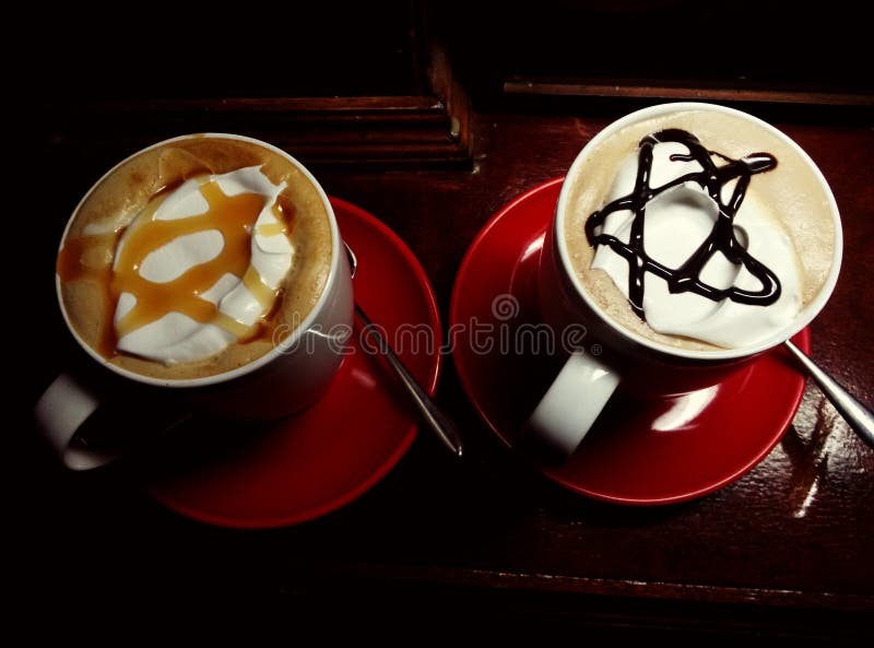 2 cups of creamy coffee topped with star-shaped sauce. 2 cups of creamy coffee topped with star-shaped sauce