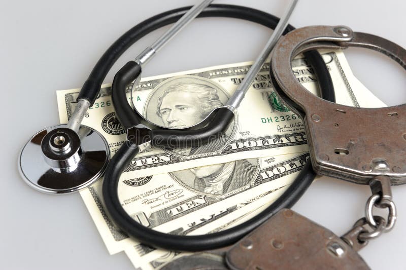 Stethoscope, handcuffs and money on gray background. Stethoscope, handcuffs and money on gray background