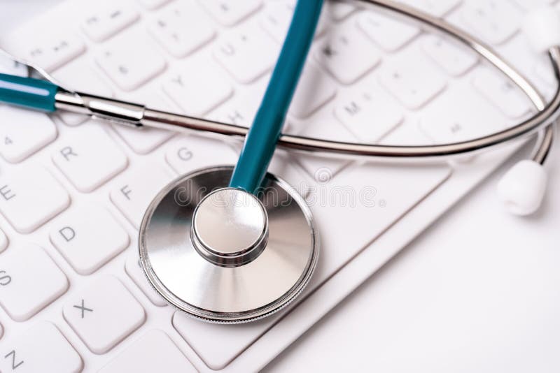 Stethoscope on computer keyboard on white background. Physician write medical case long term care treatment concept, close up