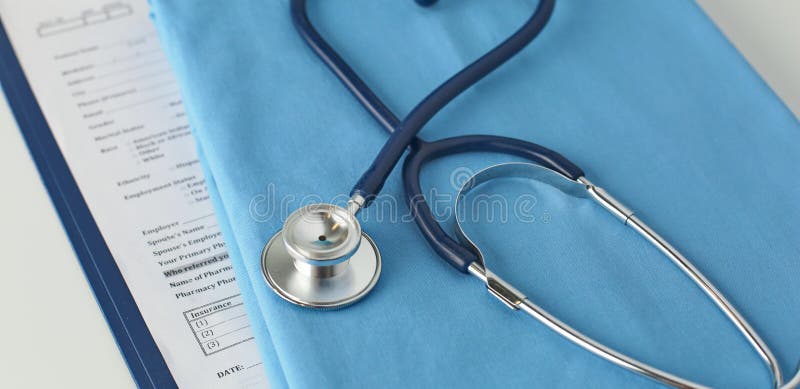 A stethoscope shaping a heart and a clipboard on a medical uniform, closeup