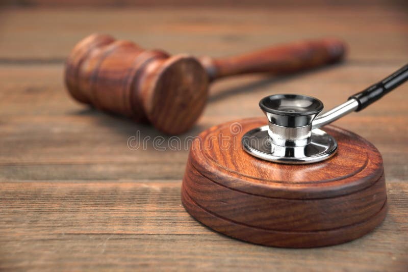 Stetoscope en Echte Rechtershamer op Bruine Houten Achtergrond royalty-vrije stock afbeeldingen Stetoscope en Echte Rechtershamer op Bruine Houten Achtergrond royalty-vrije stock afbeeldingen