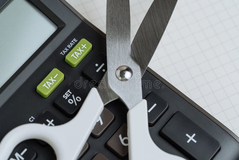 Steuersenkung, Budgetreduzierung, Schuldausschnittkonzept, weiße Scheren auf schwarzem Taschenrechner mit grünem Knopf mit Steuer