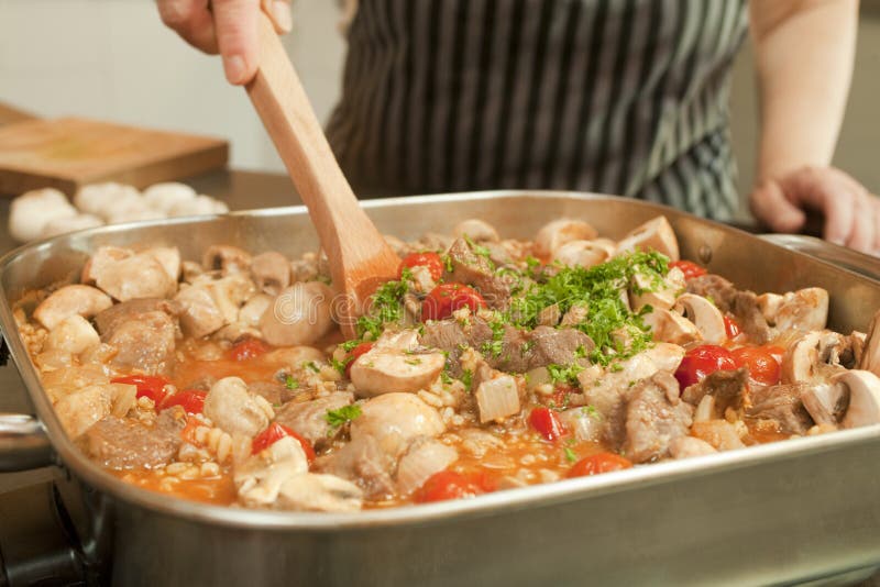 Woman cooking a large, family size stew in an electric frying pan. Frying pan stock images, royalty-free photos and pictures