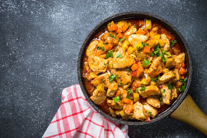 Stew κοτόπουλου με το μαύρο πίνακα πετρών λαχανικών, τοπ άποψη στοκ εικόνες με δικαίωμα ελεύθερης χρήσης Stew κοτόπουλου με το μαύρο πίνακα πετρών λαχανικών, τοπ άποψη στοκ εικόνες με δικαίωμα ελεύθερης χρήσης