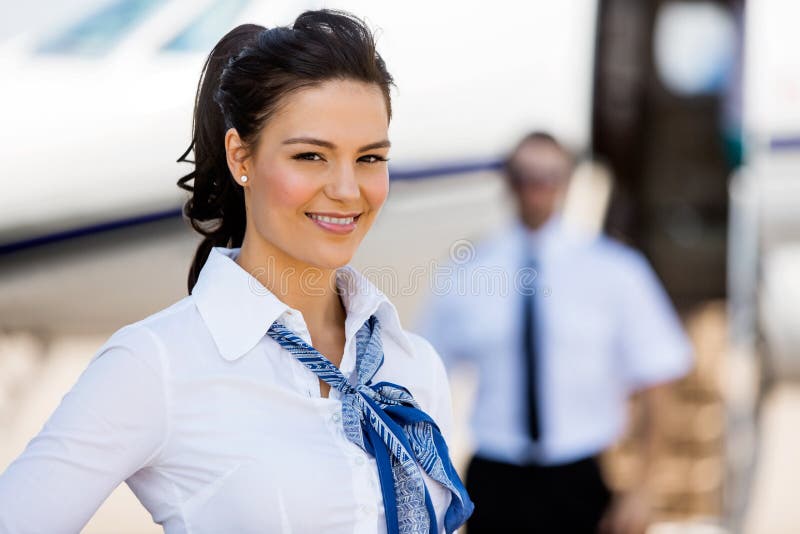 Stewardesses Smiling With Pilot And Private Jet In royalty free stock photography