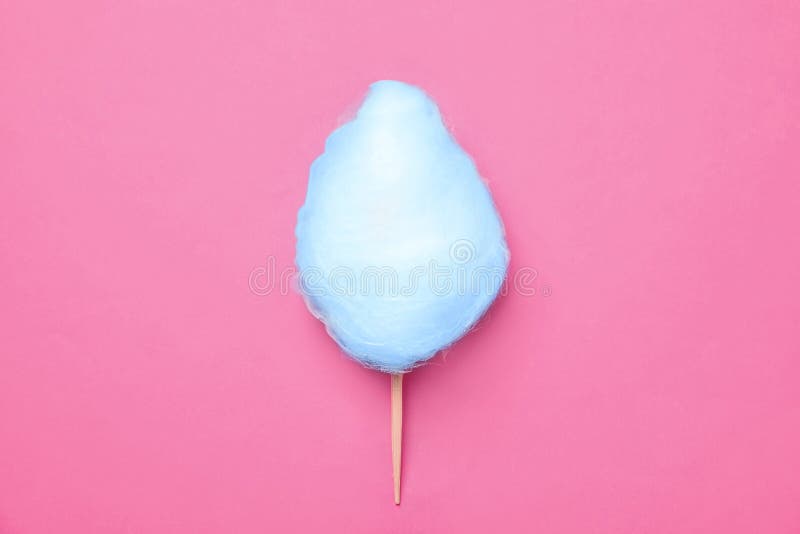 Stick with blue yummy cotton candy on pink, top view