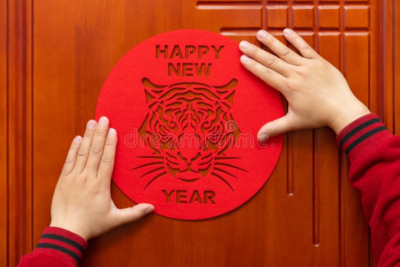 Sticking Chinese New Year of tiger 2022 mascot to the door translation of the Chinese is happy new tiger year