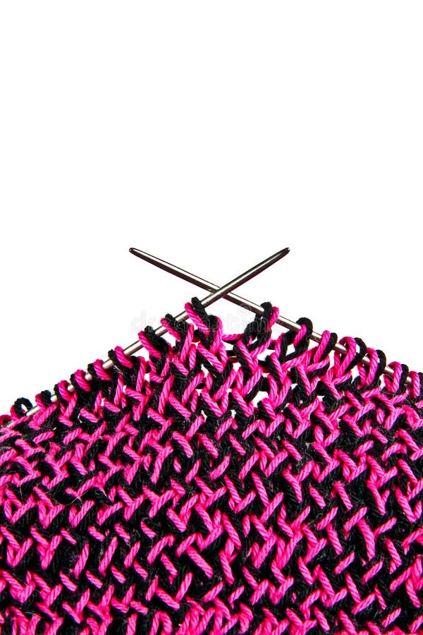 Knitting with pink and black wool, on metal knitting needles. close-up view, over white. Knitting with pink and black wool, on metal knitting needles. close-up view, over white.