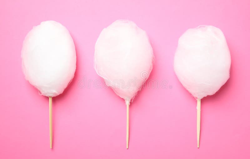 Sticks with yummy cotton candy on color background