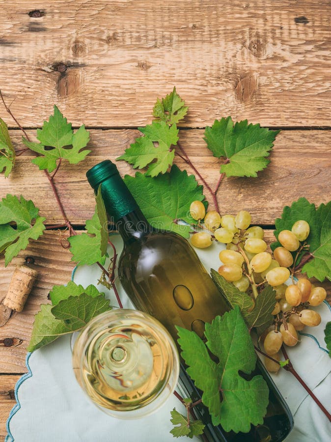 Sticlă de vin alb și sticlă și struguri proaspeți pe fond de lemn royalty free stock images