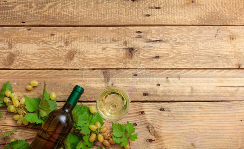 Sticlă de vin alb și sticlă și struguri proaspeți pe fond de lemn royalty free stock photos
