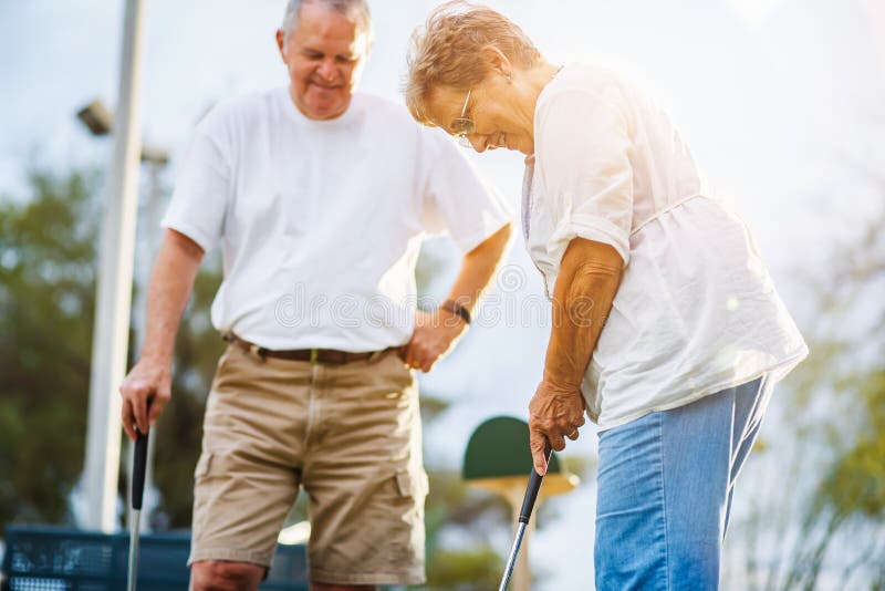 Stile di vita pensionato delle coppie senior che giocano mini golf fotografie stock libere da diritti Stile di vita pensionato delle coppie senior che giocano mini golf fotografie stock libere da diritti