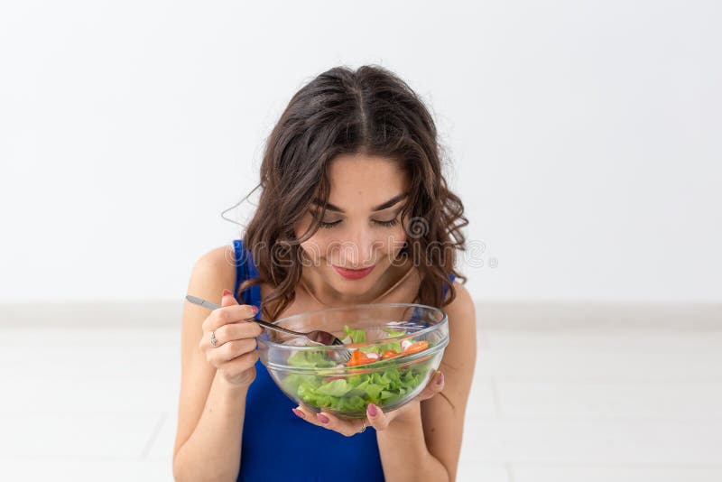 Healthy lifestyle, people and sport concept - Yoga woman with a bowl of vegetable salad. Healthy lifestyle, people and sport concept - Yoga woman with a bowl of vegetable salad.