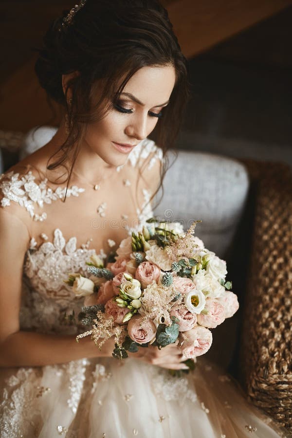 Stilfull bukett av rosa och vita blommor i händerna av den härliga modellflickan i moderiktig bröllopsklänning arkivbild Stilfull bukett av rosa och vita blommor i händerna av den härliga modellflickan i moderiktig bröllopsklänning arkivbild