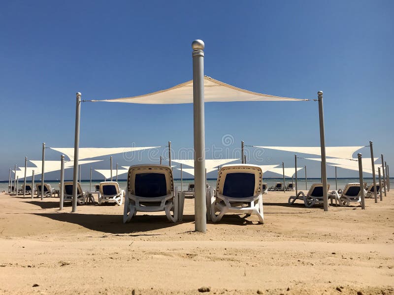 Stilfull dagdrivare i gul sand till solen sunbed på stranden i sommar under öppen himmel royaltyfria foton Stilfull dagdrivare i gul sand till solen sunbed på stranden i sommar under öppen himmel royaltyfria foton