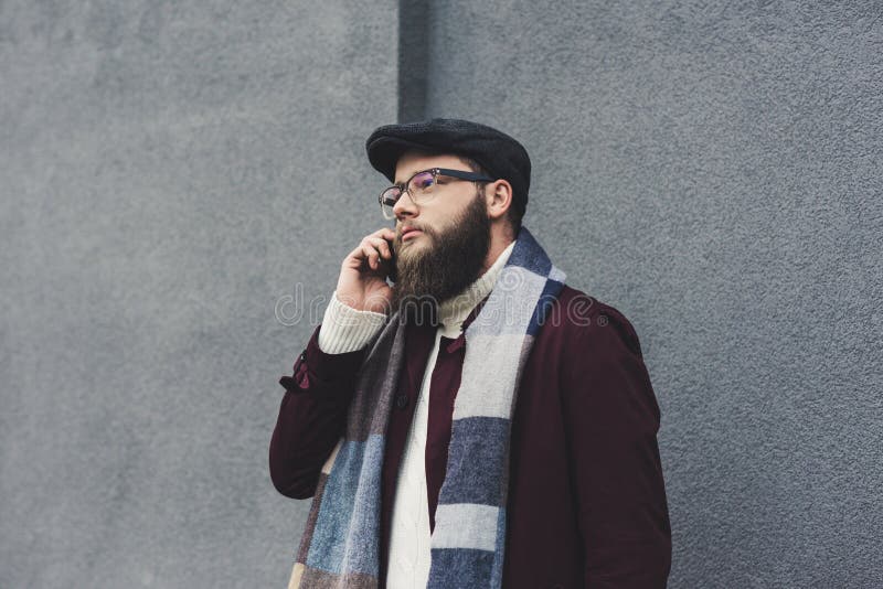 stilfull skäggig man som framme talar vid telefonen av arkivfoto stilfull skäggig man som framme talar vid telefonen av arkivfoto