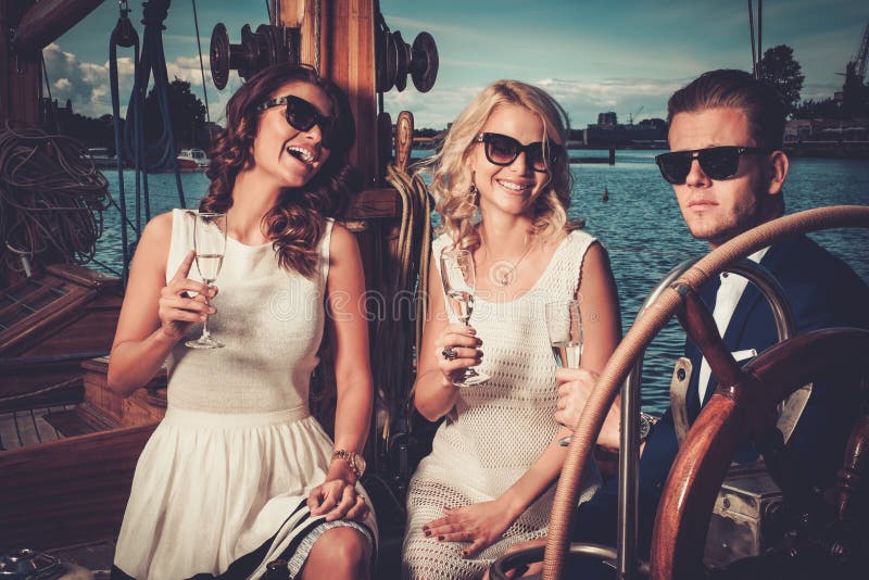 Stilfulla vänner som har gyckel på en yacht royaltyfria bilder Stilfulla vänner som har gyckel på en yacht royaltyfria bilder