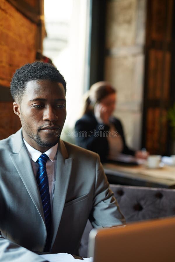 Stilig afrikansk affärsman i arbetande vardagsrum royaltyfri bild Stilig afrikansk affärsman i arbetande vardagsrum royaltyfri bild
