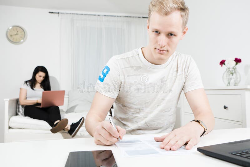 Stilig blond man som skriver på skrivbordet royaltyfri foto Stilig blond man som skriver på skrivbordet royaltyfri foto