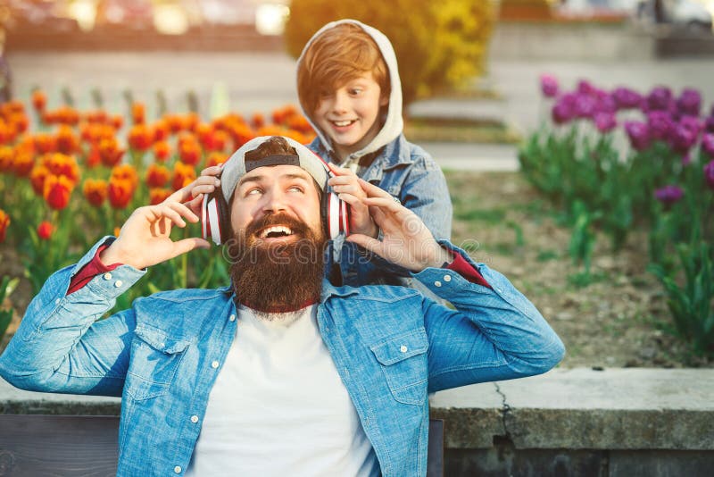 Stilig le fader och hans son som tycker om musik på staden Fader och unge som tillsammans spenderar tid utomhus Den lyckliga fami royaltyfri bild Stilig le fader och hans son som tycker om musik på staden Fader och unge som tillsammans spenderar tid utomhus Den lyckliga fami royaltyfri bild