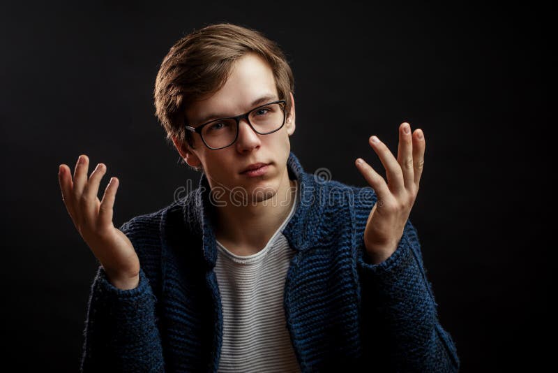 Stilig man i tröja som förklarar något med lyftta händer arkivfoto Stilig man i tröja som förklarar något med lyftta händer arkivfoto