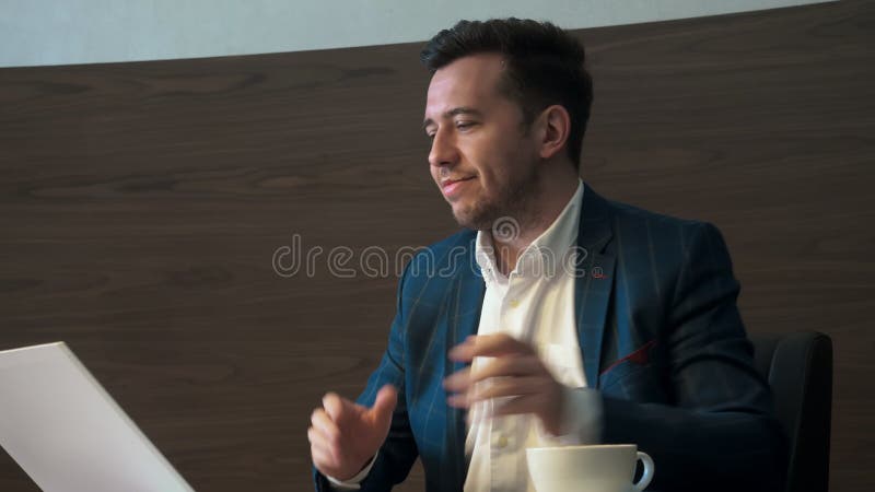 Stilig man som dricker kaffe från koppsammanträde på tabellen i affärskontor arkivfilmer