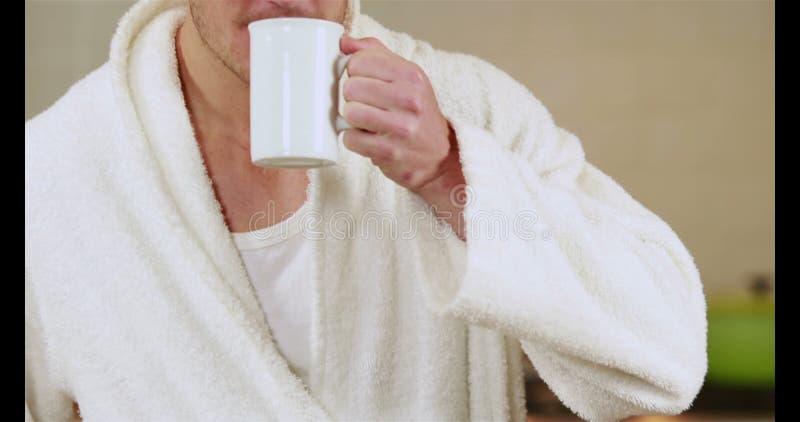 Stilig man som dricker kaffe i badämbetsdräkt stock video