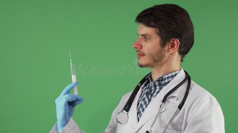 Stilig manlig doktor som förbereder injektionssprutan med vaccinen fotografering för bildbyråer Stilig manlig doktor som förbereder injektionssprutan med vaccinen fotografering för bildbyråer