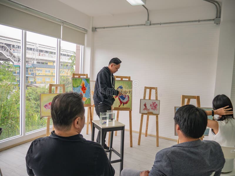 Stilig ung asiatisk man- eller vattenfärgkonstnär Teaching hur man målar i studio royaltyfria bilder Stilig ung asiatisk man- eller vattenfärgkonstnär Teaching hur man målar i studio royaltyfria bilder