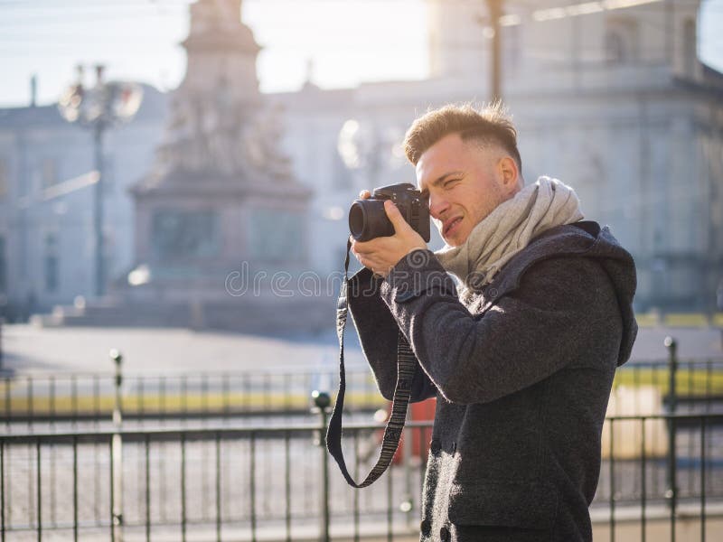 Stilig ung manlig fotograf som tar det utomhus- fotografiet arkivbild Stilig ung manlig fotograf som tar det utomhus- fotografiet arkivbild