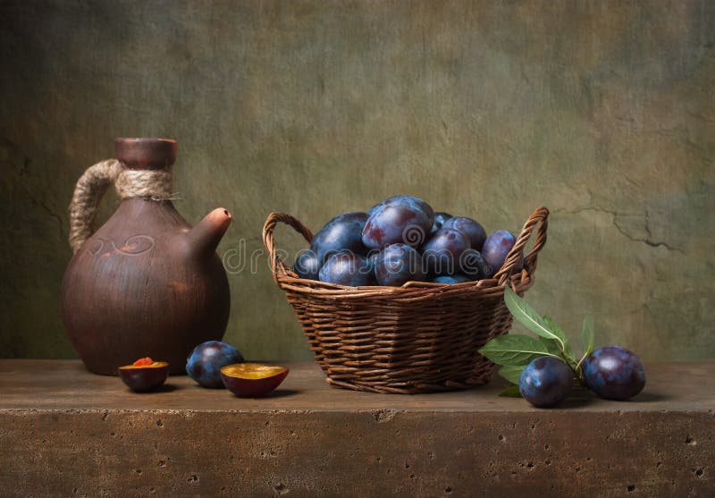 Still life with black plums in a basket