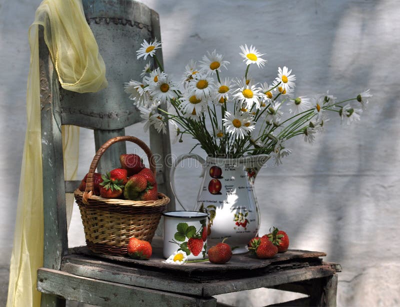 Still life with camomiles and basket of strawberry