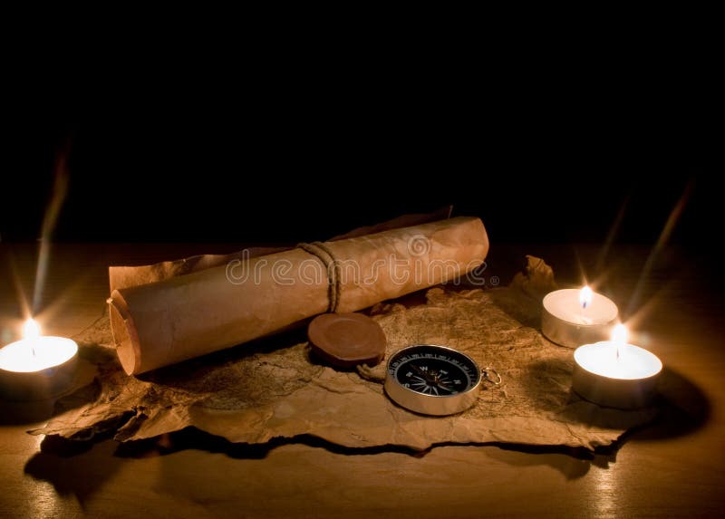 Still life with candles by a compass and old maps