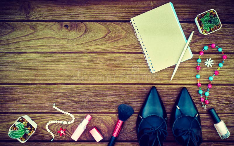 Still life of fashion women. Feminine cosmetic background. Black patent leather shoes and blank notebook on the wooden floor. Still life of fashion women. Feminine cosmetic background. Black patent leather shoes and blank notebook on the wooden floor.