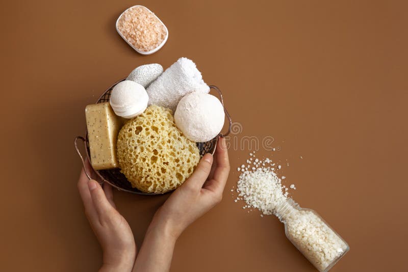 Female hands with spa products on a brown background. Body care concept