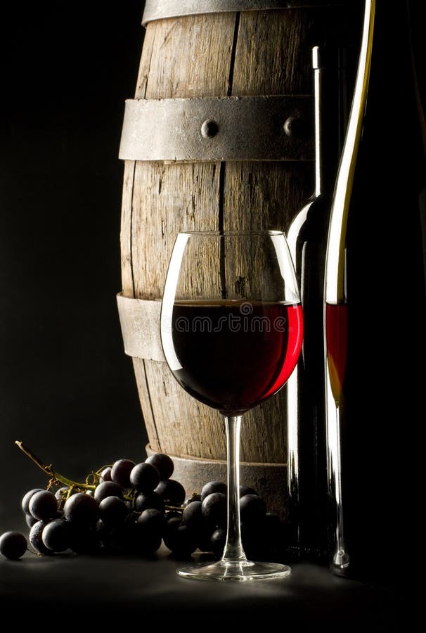 Ancora vita con bicchieri di vino rosso, una bottiglia e l'uva.