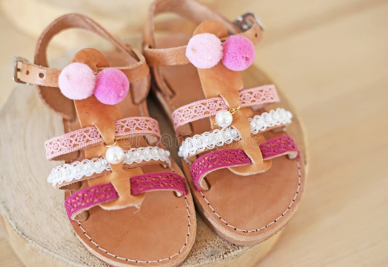 Greek leather sandals with pink tassel and pom pom for girls - kids shoes advertisement royalty free stock image Greek leather sandals with pink tassel and pom pom for girls - kids shoes advertisement royalty free stock image