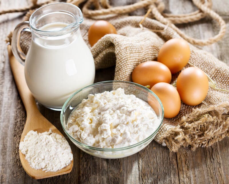 Milk, Cottage Cheese, Eggs and Flour on Wooden Table Stock Photo
