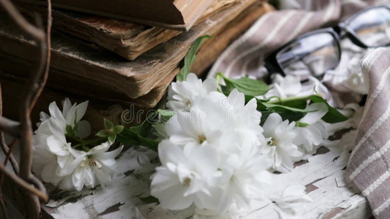 Still life with an old book, a metal mug and white flowers. composition in a rustic style.