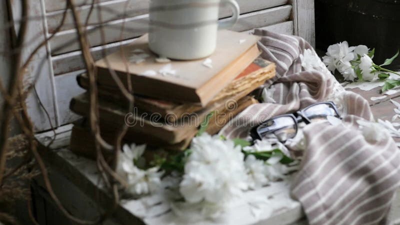 Still life with an old book, a metal mug and white flowers. composition in a rustic style.