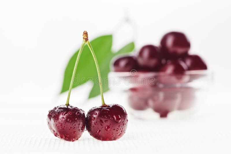 Still life with pair of red cherry and glass bowl stock photo