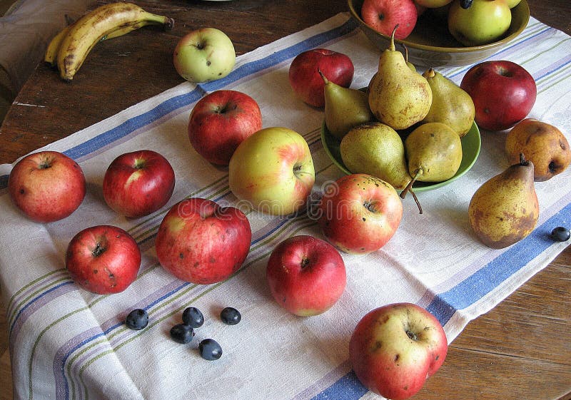 Still life of red apples, green pears and grapes on towel stock image