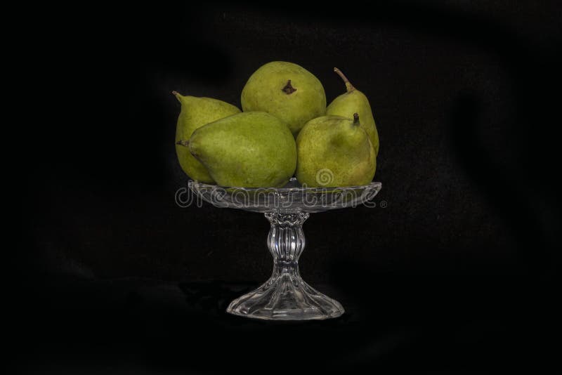 Still life. Ripe pears in a glass vase on a black background stock images Still life. Ripe pears in a glass vase on a black background stock images