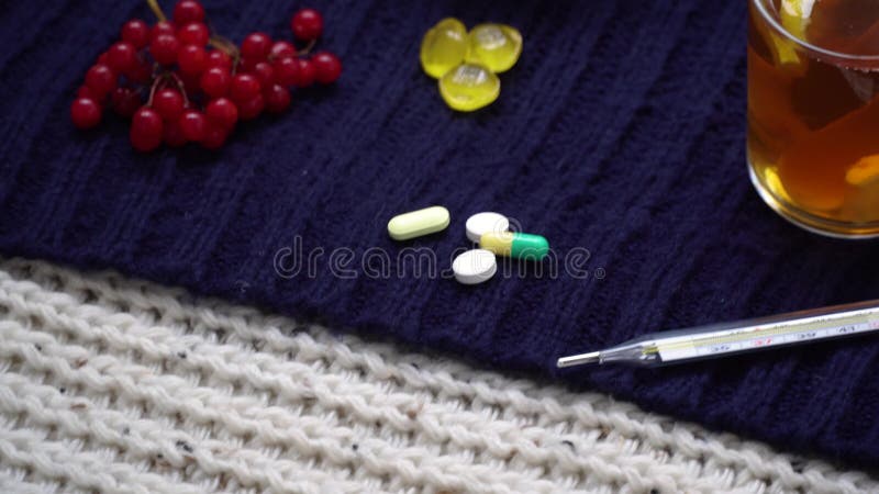 Still life of tea with lemon, tablets and thermometer, jam and berries. The concept of treating colds