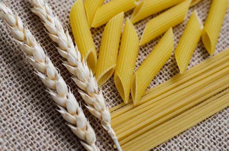 Stilleben för ett kök av veteöron och pasta från vete på en säckvävbakgrund som göras i Kasakhstan royaltyfri foto Stilleben för ett kök av veteöron och pasta från vete på en säckvävbakgrund som göras i Kasakhstan royaltyfri foto