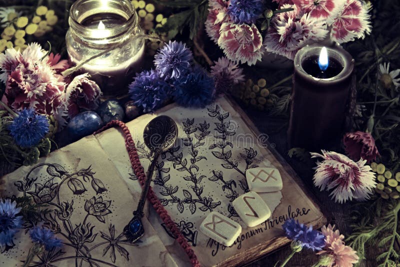 Stilleven met oud boek met botanische tekening, zwarte kaars en bloemen in mysticuslicht stock foto Stilleven met oud boek met botanische tekening, zwarte kaars en bloemen in mysticuslicht stock foto