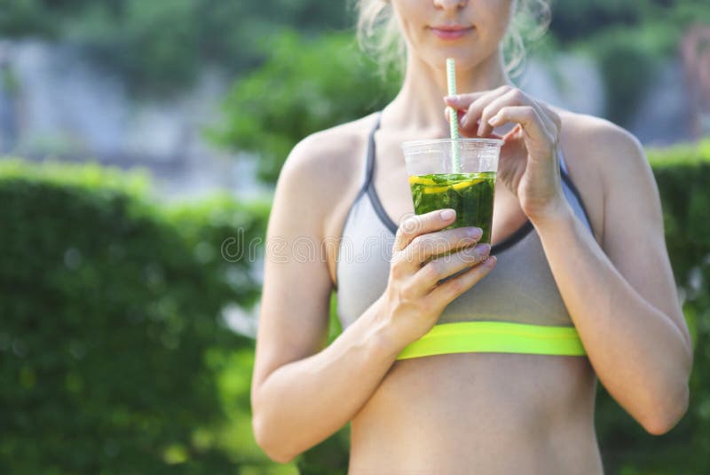 Stillstehendes trinkendes organisches Getränk der Eignungsathleten-Frau lizenzfreies stockbild Stillstehendes trinkendes organisches Getränk der Eignungsathleten-Frau lizenzfreies stockbild