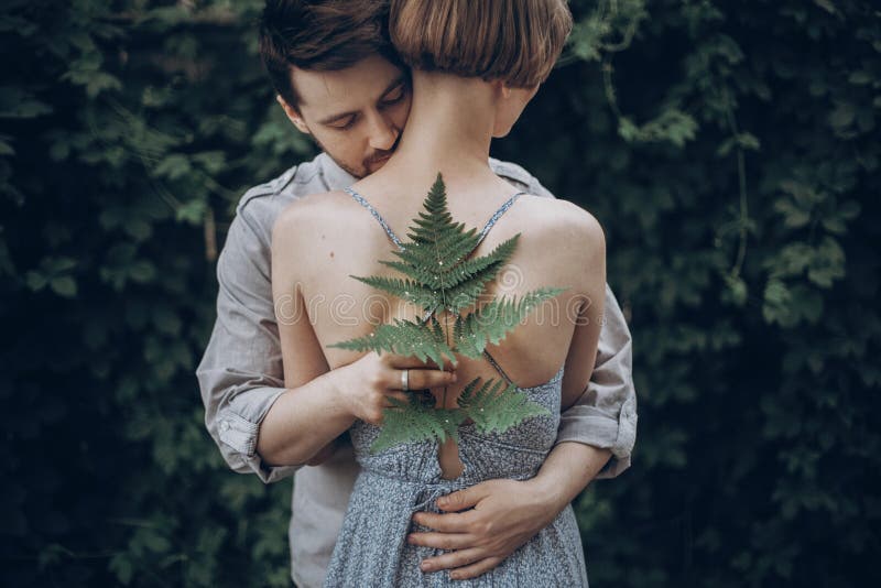 Stilvolle Hippie-Braut und -bräutigam, die im Grünblattwald umfasst lizenzfreie stockbilder Stilvolle Hippie-Braut und -bräutigam, die im Grünblattwald umfasst lizenzfreie stockbilder