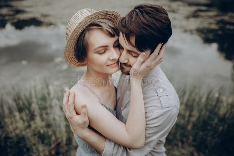 Stilvolle Hippie-Paare, die am See umarmen Mann und Frau in modernem lizenzfreies stockbild Stilvolle Hippie-Paare, die am See umarmen Mann und Frau in modernem lizenzfreies stockbild